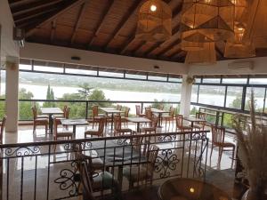 restauracja ze stołami i krzesłami oraz balkonem w obiekcie Tagore Suites Hotel w mieście Villa Carlos Paz