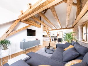 a living room with wooden ceilings and a blue couch at Alte Schule Tiefenbach in Tiefenbach