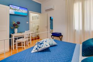 Namuri Rooms في شاكا: غرفة نوم زرقاء مع سرير وطاولة