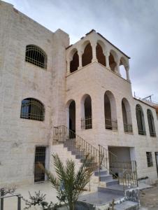 - un ancien bâtiment en pierre avec des escaliers devant dans l'établissement Twilight Hotel Petra, à Wadi Musa