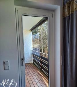 a door leading to a balcony with a window at Ferienwohnung AllgOy in Oy-Mittelberg