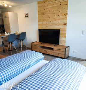 1 dormitorio con 2 camas y TV de pantalla plana en Ferienwohnung AllgOy en Oy-Mittelberg