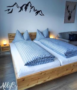a bedroom with two beds with blue and white pillows at Ferienwohnung AllgOy in Oy-Mittelberg