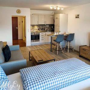a living room and kitchen with a couch and a table at Ferienwohnung AllgOy in Oy-Mittelberg