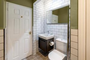 a bathroom with a sink and a toilet and a mirror at Garden maisonette in Bath city centre in Bath +19 photos