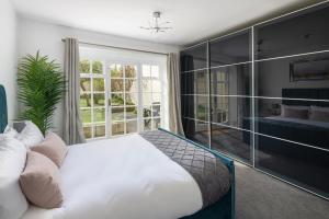 a bedroom with a white bed and a large window at Garden maisonette in Bath city centre in Bath