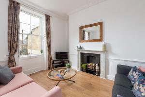 a living room with a couch and a table at Garden maisonette in Bath city centre in Bath