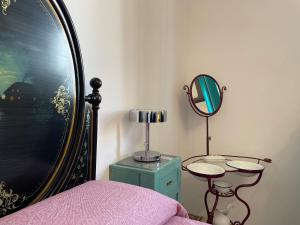 una camera da letto con specchio e tavolo con lampada di CASA SIMONETTA a San Gimignano