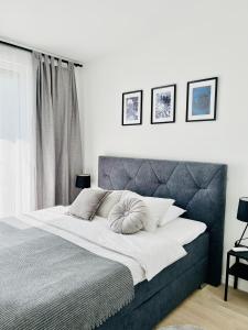 a bedroom with a large bed with a gray headboard at Apt Ljupka - Zadar - with private free parking in Zadar