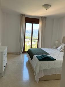1 dormitorio con cama y ventana grande en Socrates Holiday Rental, La Mairena - El Soto Golf Club FREE PADEL GYM TENNIS & GOLF en Ojén