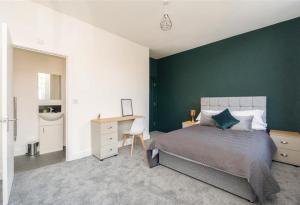 um quarto com uma parede verde, uma cama e uma secretária em King St Contractor Accommodation 6 bed 6 bath free parking for vans em Wallasey