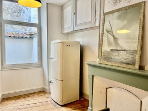 a white refrigerator in a room with a fireplace at Dormir À La Rochelle 1 avec Parking in La Rochelle