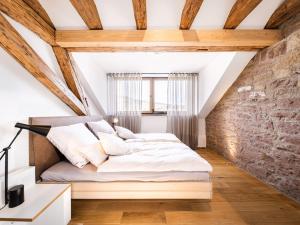 Bett in einem Zimmer mit Ziegelwand in der Unterkunft Alte Schule Tiefenbach in Tiefenbach