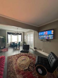 a living room with a couch and a tv at Cozy vintage getaway minutes from downtown in Lincoln