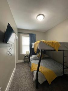 a bedroom with two bunk beds and a flat screen tv at Cozy vintage getaway minutes from downtown in Lincoln