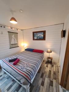 Un dormitorio con una cama con almohadas rojas. en La Chaloupe, en Saint-Pierre-Quiberon