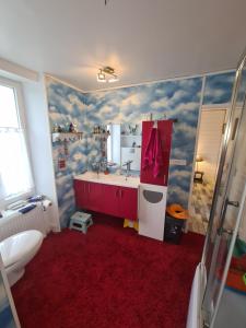 baño con lavabo y alfombra roja en La Chaloupe, en Saint-Pierre-Quiberon