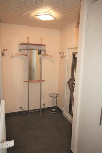uma casa de banho com um espelho e uma prateleira num quarto em Haus Ingrid em Norddeich
