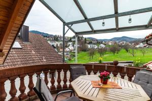 una mesa de madera y sillas en un balcón con vistas en Burgblick en Lauf