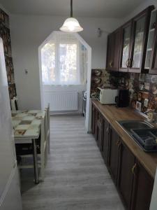 a kitchen with a table and a dining room at Family Rooms Hunedoara in Hunedoara