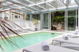 una piscina con un salón acristalado con techo de cristal en AWA Boutique + Design Hotel, en Punta del Este