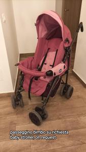 a pink baby stroller sitting on a wooden floor at BELLA PALERMO in Palermo