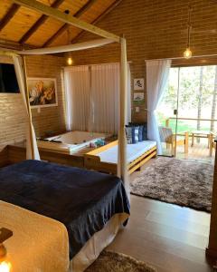 een slaapkamer met een bed en een bad. bij Chalés Villa Caravaggio in Santa Teresa