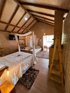 sypialnia z dużym łóżkiem w pokoju w obiekcie Chalés Villa Caravaggio w mieście Santa Teresa