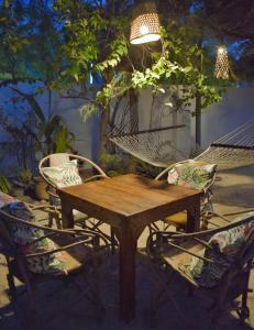 een houten tafel, 2 stoelen en een hangmat bij Maryam Garden Apartments & Villa in Bwejuu