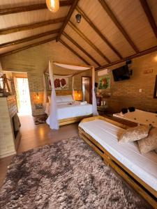 um quarto amplo com 2 camas e um tapete em Chalés Villa Caravaggio em Santa Teresa