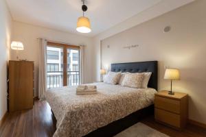 um quarto com uma cama grande e uma janela em Modern & Elegant 2 bedroom in Amadora by GT House na Amadora