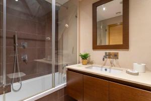 un bagno con doccia, lavandino e specchio di Modern & Elegant 2 bedroom in Amadora by GT House ad Amadora Altre 22 foto