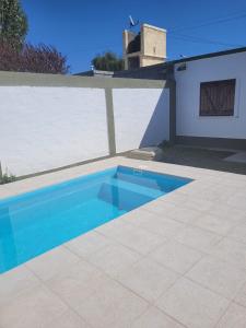 una piscina azul junto a una casa en La Piccolina en Tunuyán