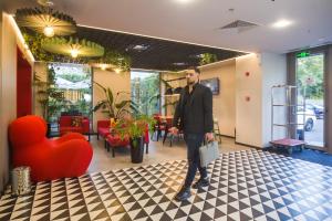 a man is standing in a room with a lobby at ibis Bucharest Politehnica in Bucharest