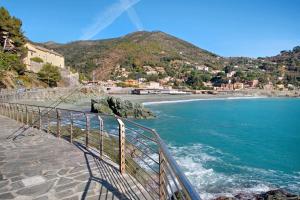 un puente sobre una playa con una montaña en el fondo en Casa mare montaretto 2, en Bonassola