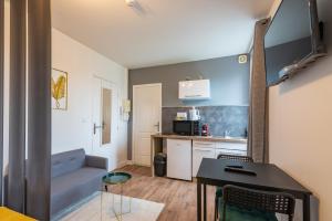 mały apartament z niebieską kanapą i kuchnią w obiekcie Bistrot 8 w mieście Nazelles