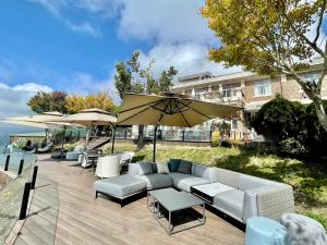 a patio with a couch and chairs and an umbrella at Ming Ging Farm in Renai