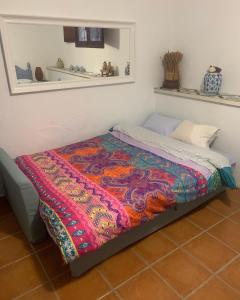 Una cama con una manta de colores en una habitación en La Buena Vida, en Cañada del Trigo