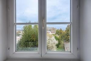 ein offenes Fenster mit Blick auf einen Hof in der Unterkunft Bistrot 8 in Nazelles