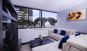 sala de estar con sofá y ventana grande en Bellini I 1, 2 habitaciones, Puerto Santa Ana, Guayaquil, en Guayaquil