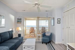 a living room with a blue couch and a table at A Dream Come True in Caswell Beach