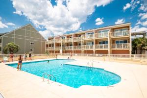 a swimming pool in front of a building at A Dream Come True in Caswell Beach