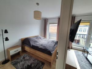 Habitación pequeña con cama y ventana en Apartament Skarbowa en Leszno