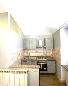 una cucina con lavandino e piano cottura forno superiore di Casa Massey a Torino