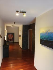 a hallway of a house with paintings on the walls at Tagore Suites Hotel in Villa Carlos Paz