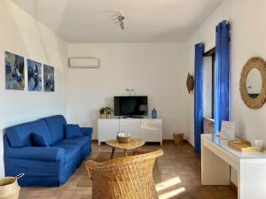 a living room with a blue couch and a tv at Sea Breeze House in Fiumicino