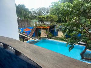 a swimming pool in a yard with a wooden fence at Lala Panzi Bed and Breakfast in Puerto Princesa City