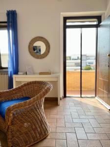 a room with a wicker chair and a desk with a window at Sea Breeze House in Fiumicino