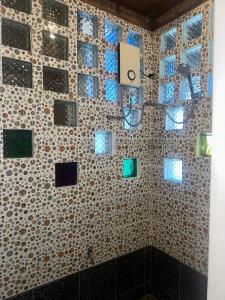 a bathroom with a tiled wall with windows and a shower at Lala Panzi Bed and Breakfast in Puerto Princesa City
