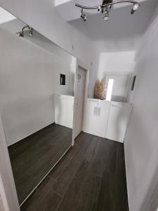 an empty room with white walls and wood floors at Sunny rooms in Dubrovnik